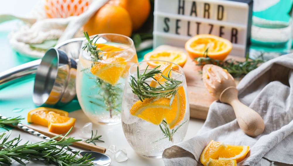 Two glasses of hard seltzer with lemon slices and rosemary twigs (shutterstock)
