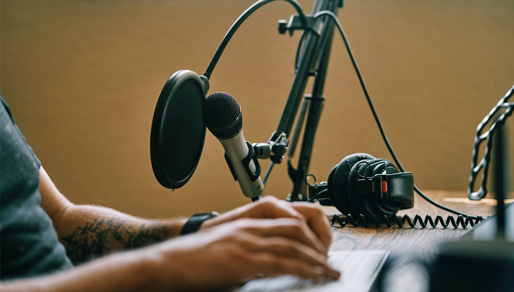 Person with recording equipment (Photo by ConvertKit on Unsplash)