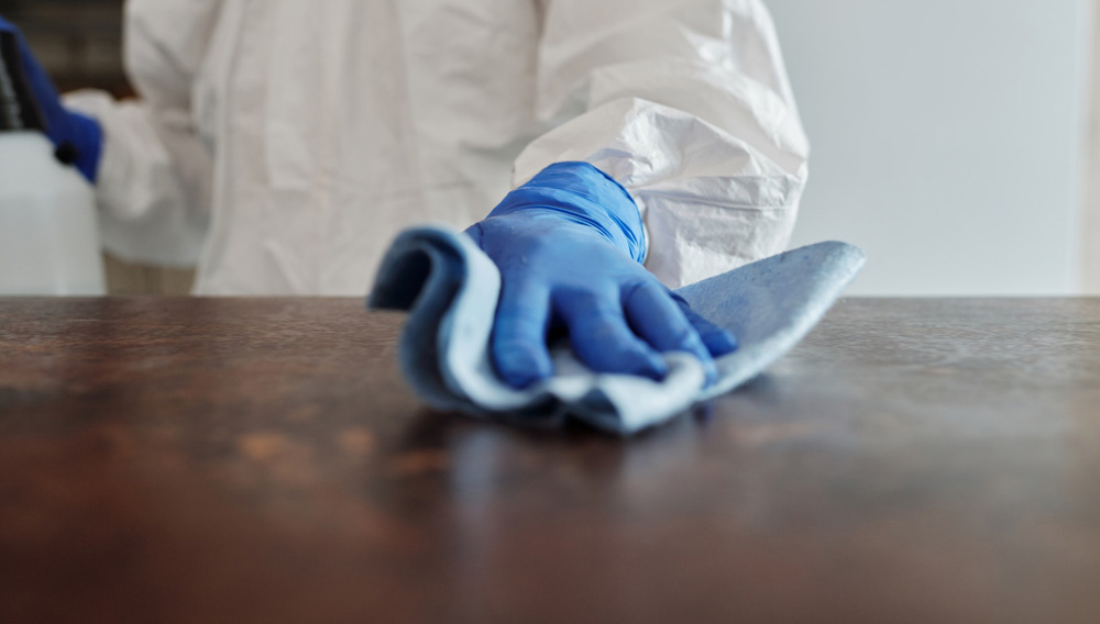 A hand wiping a surface clean (Photo: Matilda Wormwood on Pexels)