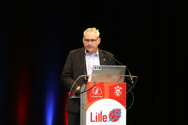 John Brauer standing at a lectern and speaking into a microphone at the EBC 2024 in Lille John Brauer at the EBC 2024 in Lille