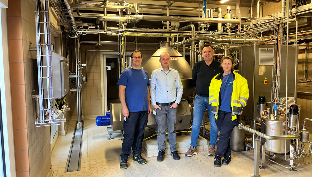 Four people in front of the new separator at Karlsberg (Photo: Karlsberg/Alfa Laval)