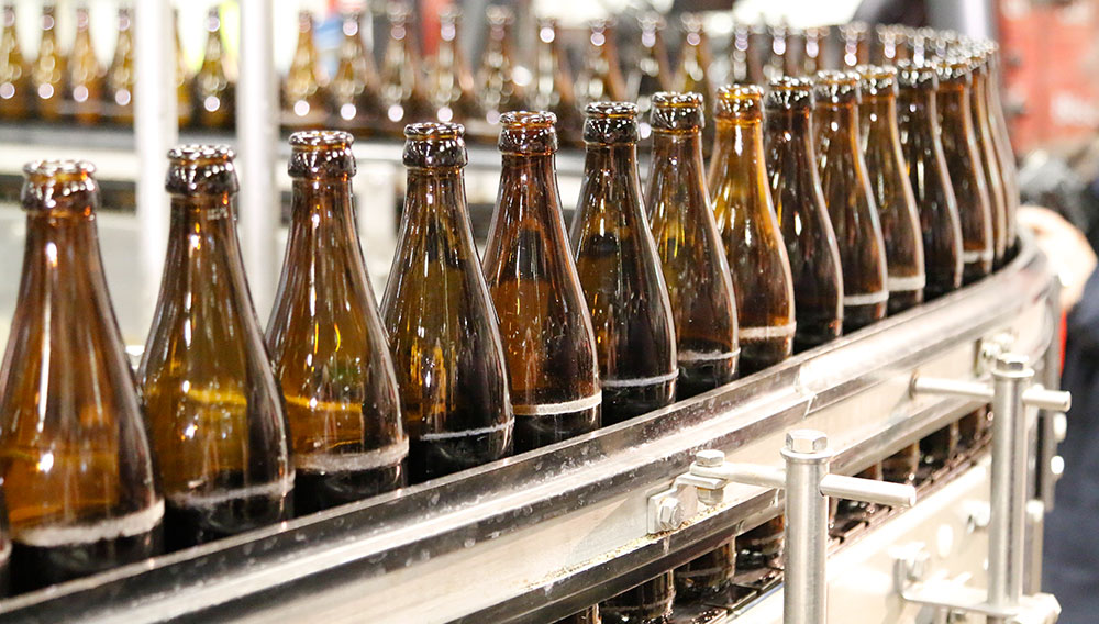 Bottles on a conveyor belt with visible scuffing