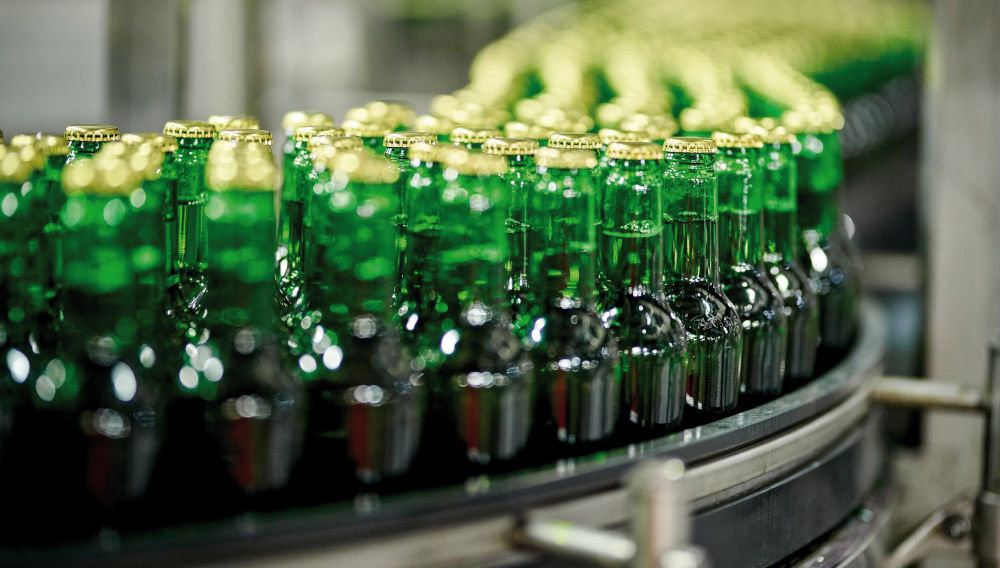 Filled green bottles on a conveyor belt