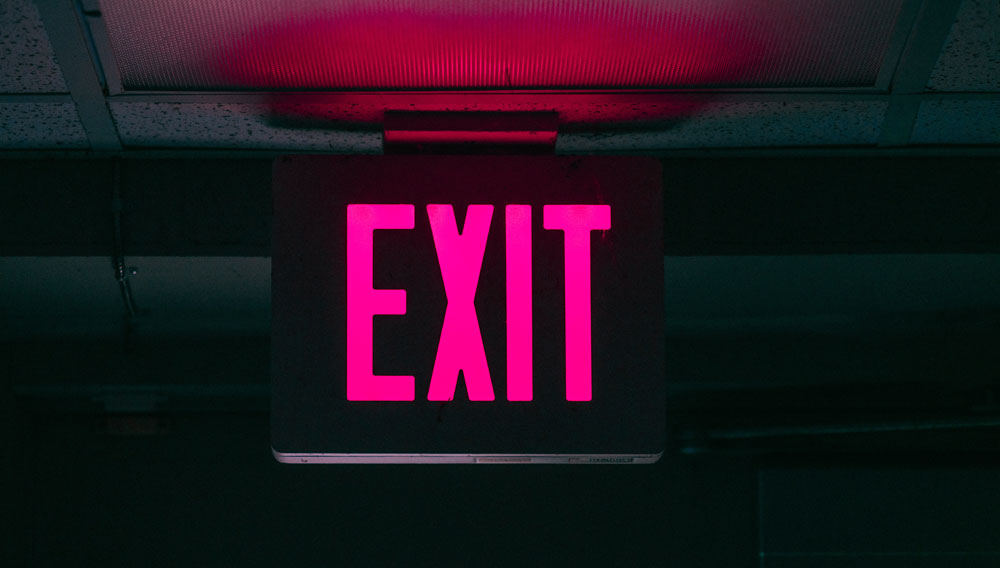 Black and pink neon “Exit” sign (Photo by Keagan Henman on Unsplash)