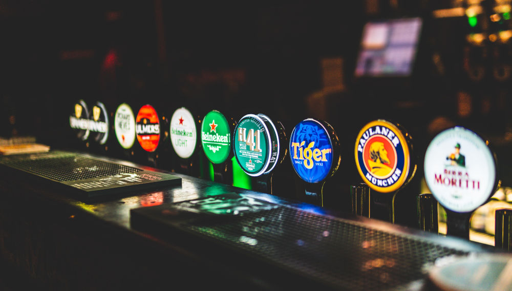 Verschiedene Front Logos bekannter Marken in einer Bar (Bild: George Bakos auf Unsplash)