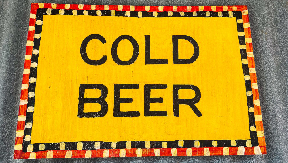Yellow painting with inscription: COLD BEER (Image: Samuel Ramos on Unsplash)