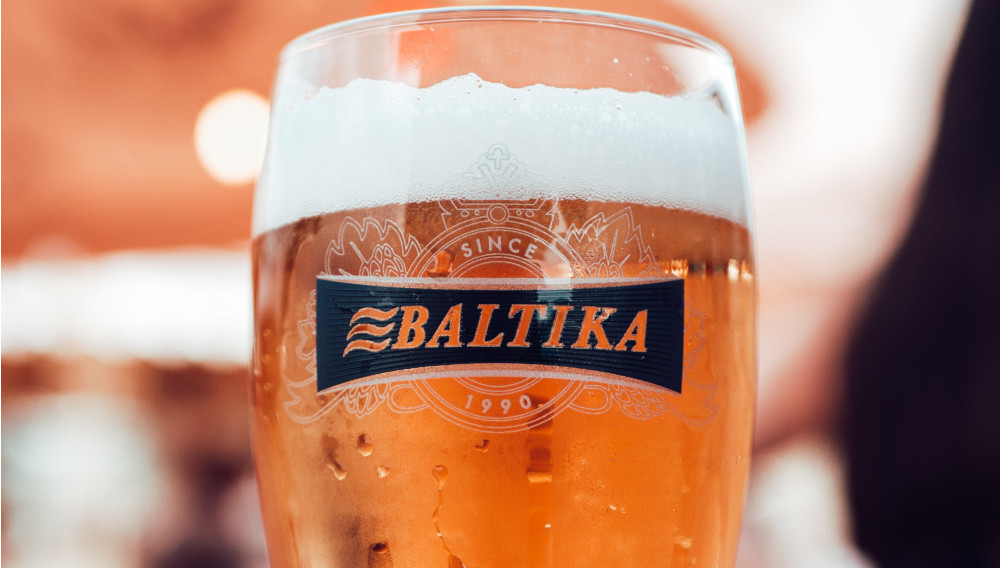 Ein mit Bier gefülltes Glas mit Baltika-Etikett (Foto: Maxim Abramov auf Unsplash)