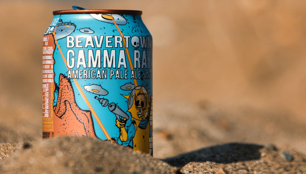 A can of beer in the sand (Photo: Jakub Pabis on Unsplash)