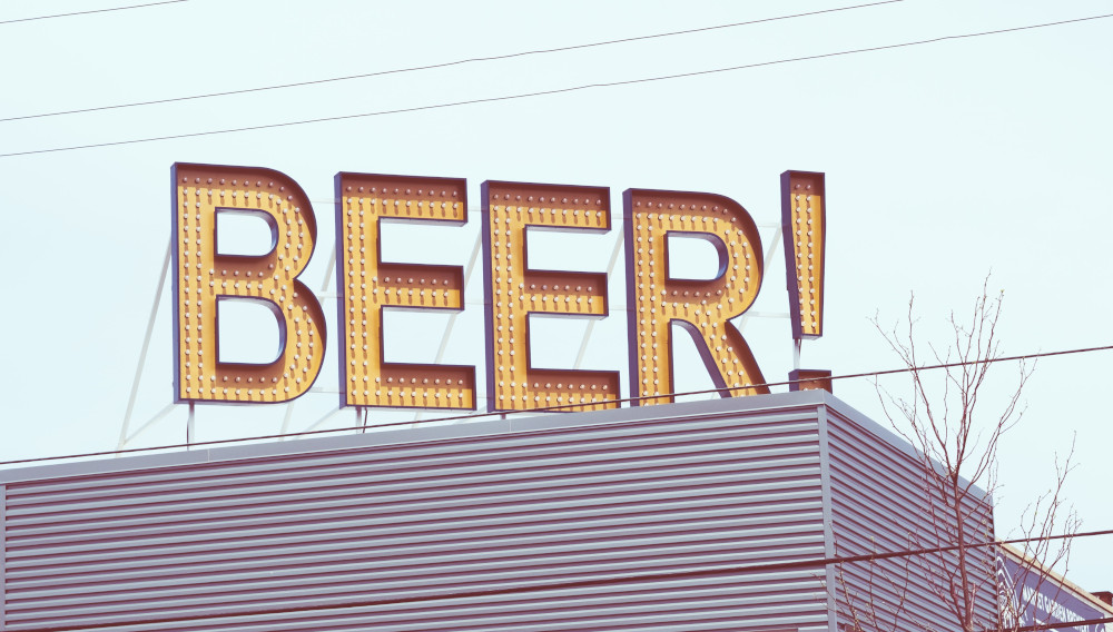 Sign saying „BEER!“ on the roof of a house (Photo: Lance Anderson on Unsplash)