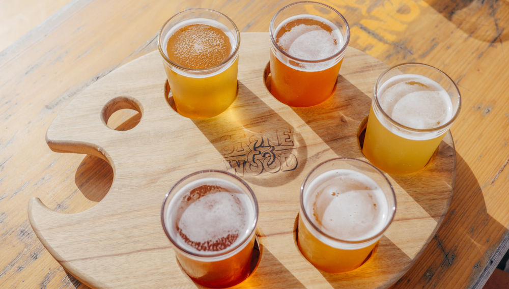 Different beers on wood (Photo: Timothy Hales Bennett on Unsplash)