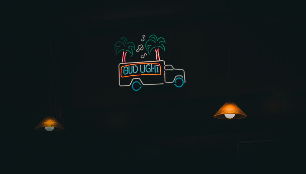 Neonschild „Bud Light“ in Form eines Busses (Foto: Rythik auf Unsplash)
