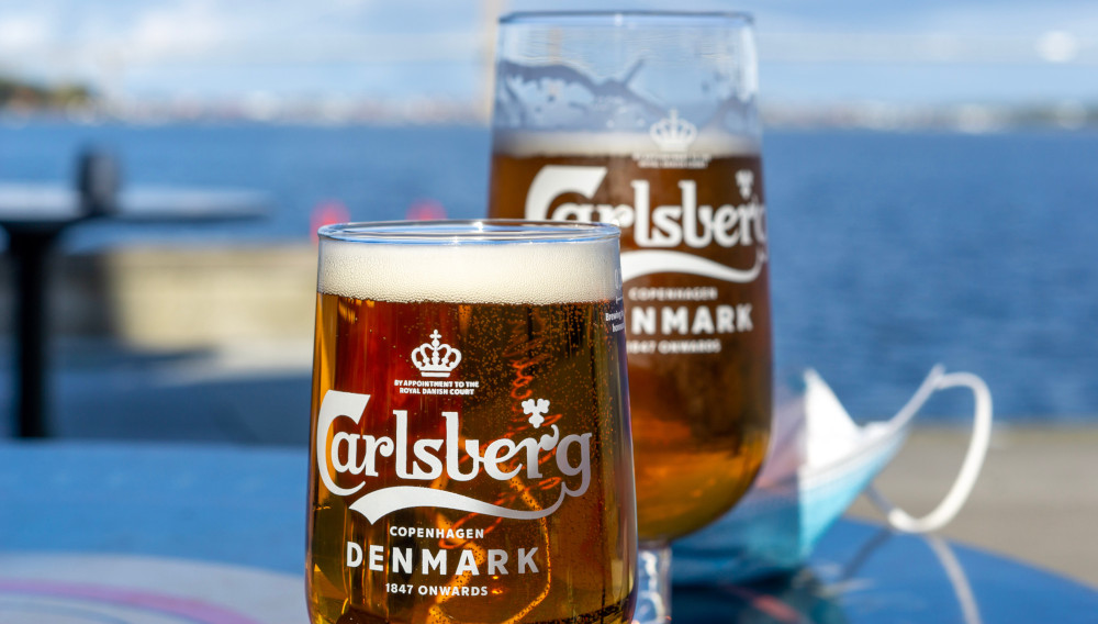 Two beer glasses with Carlsberg inscription (Photo: Elin Tabitha on Unsplash)