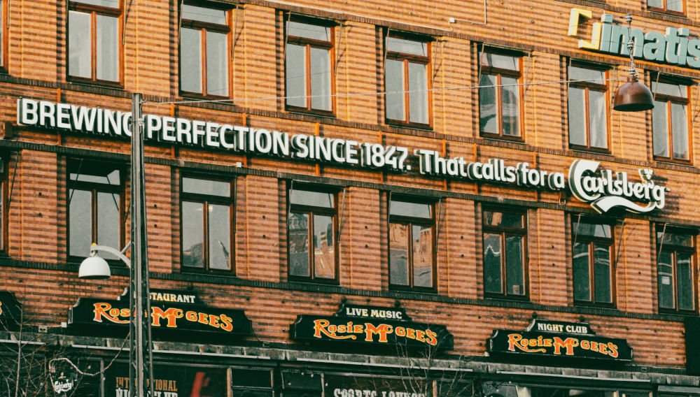 Hausfassade mit Carlsberg-Werbung (Foto: Beatriz Miller auf Unsplash)