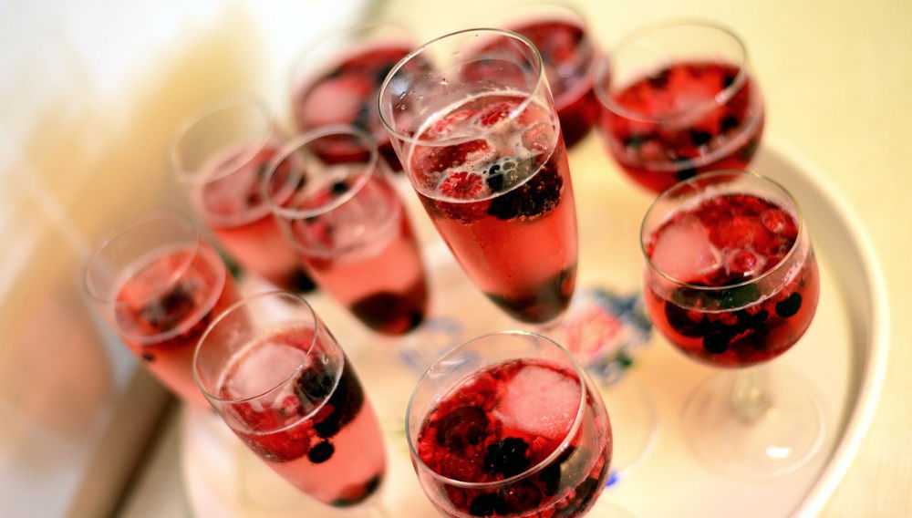 Tray with champagne glasses containing a pinkish liquor and berries (Photo: congerdesign on Pixabay)