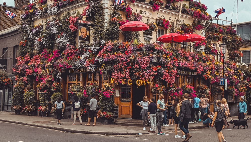 Churchill Pub in London, overgrown by flowers (Photo by Alex Motoc on Unsplash)