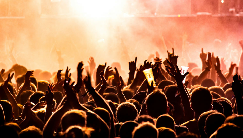 People raising their arms on a concert (Photo: Tijs van Leur on Unsplash)