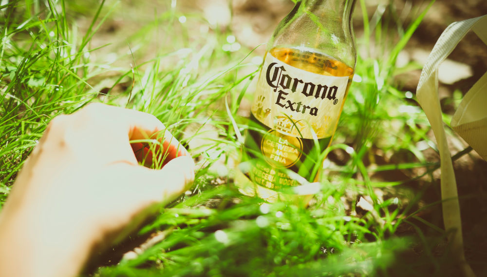 Bottle of Corona Extra on a lawn (Photo: Xiangkun ZHU on Unsplash)