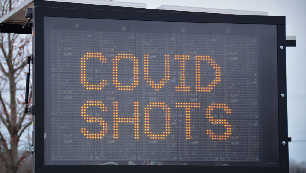 Sign promoting covid vaccination, saying “Covid shots” (Photo by Roger Starnes Sr on Unsplash)