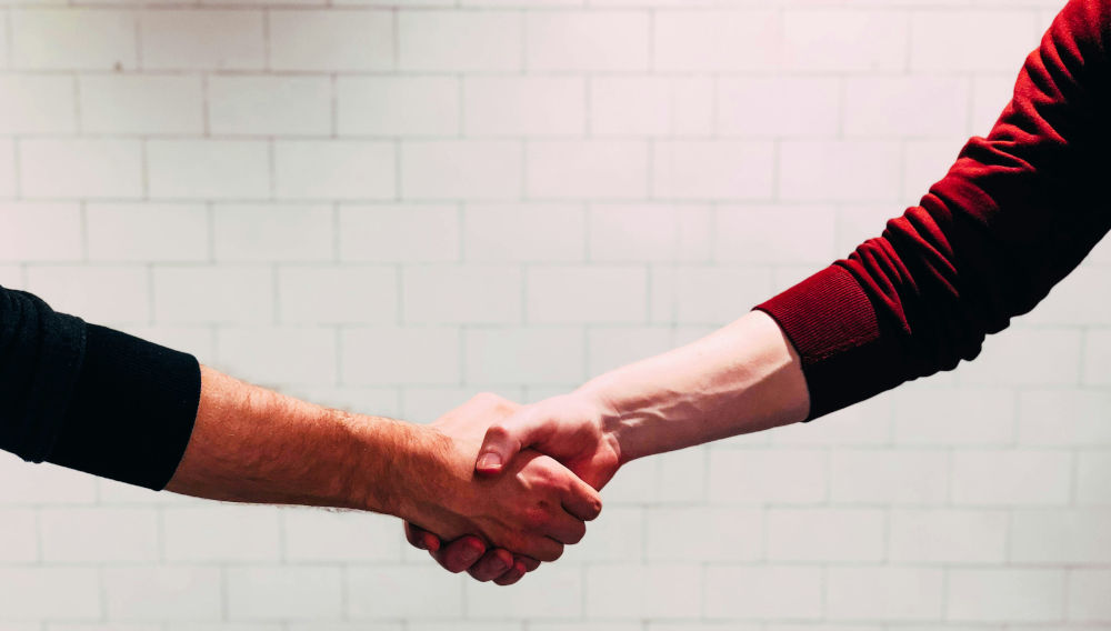 Two people shaking hands, detail (Photo: Chris Liverani on Unsplash)