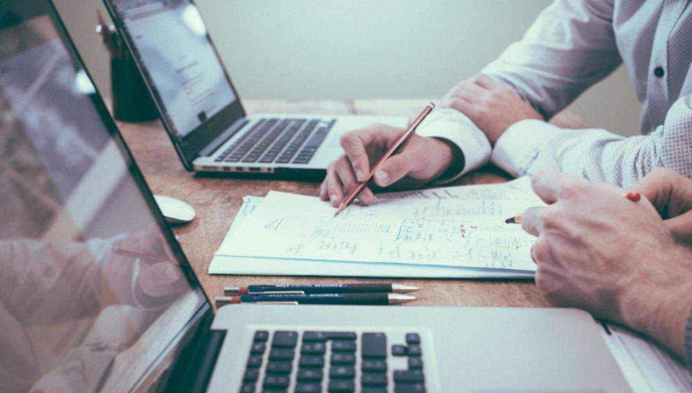 Two people working with laptops and pencil (Photo by Scott Graham on Unsplash)