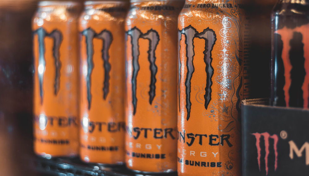 Five Monster energy drink cans (Photo: Christian Wiediger on Unsplash)