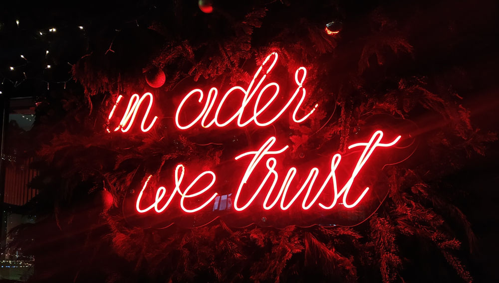 Neonbuchstaben „in cider we trust“ (Foto: Tatiana auf Unsplash)