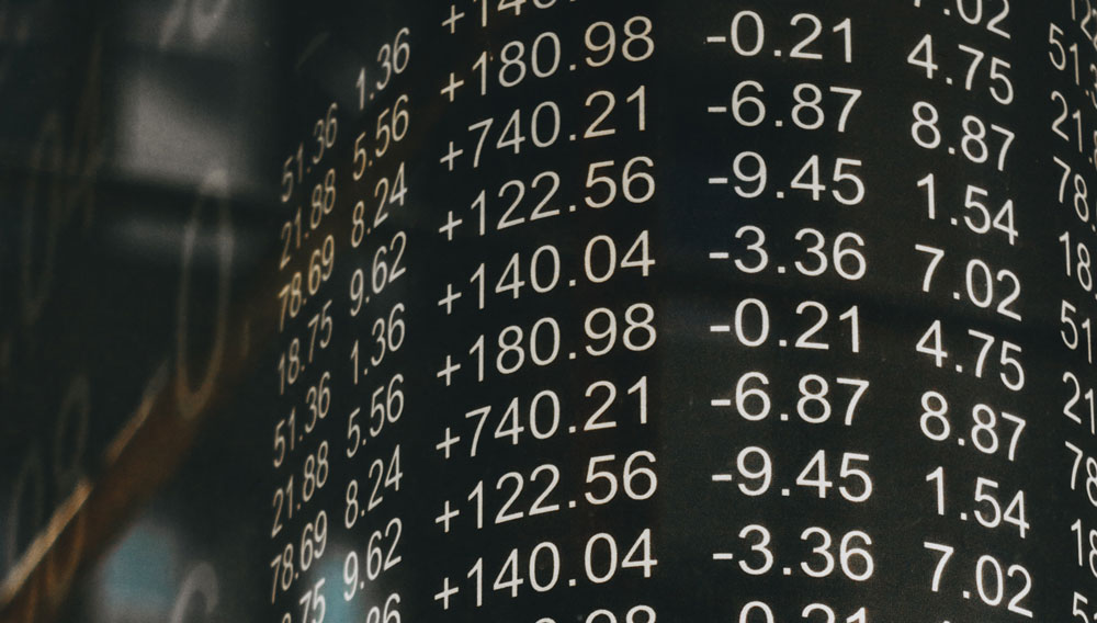 Numerical figures on a market indicator board, detail (Photo: Tyler Easton on Unsplash)