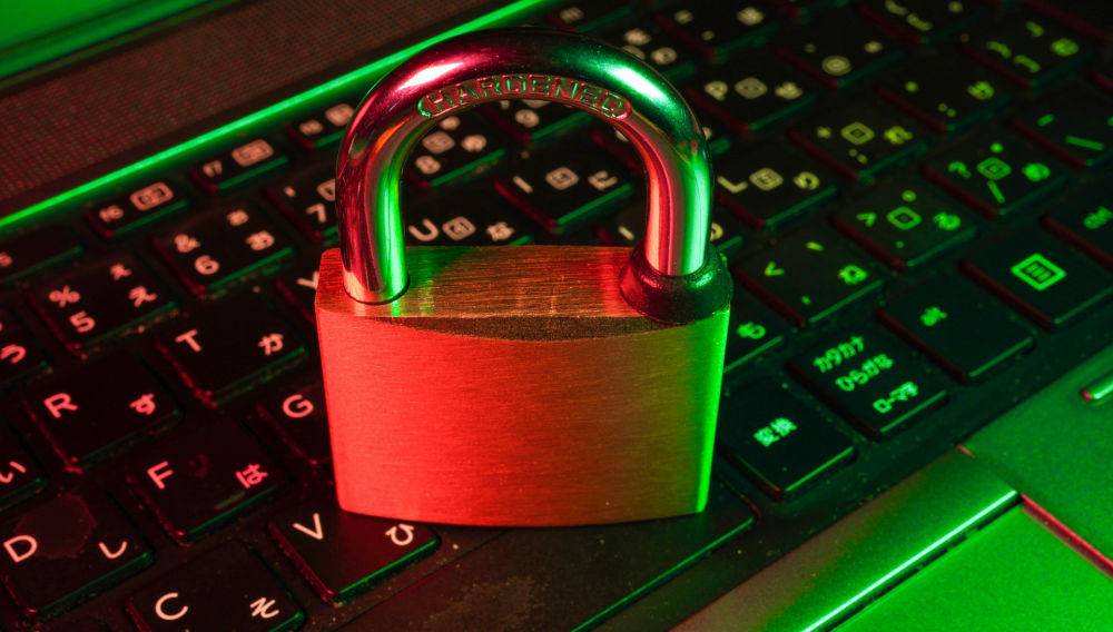 Red illuminated padlock on black computer keyboard with green light elements (Photo: FlyD on Unsplash)