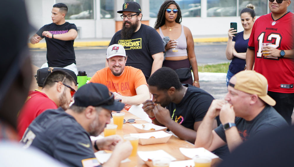 A group of people sitting around a table eating food (Photo: Growth + Co. on Unsplash)