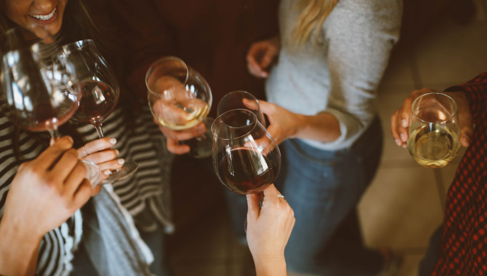Group of people holding wine glasses (Photo by Kelsey Chance on Unsplash)