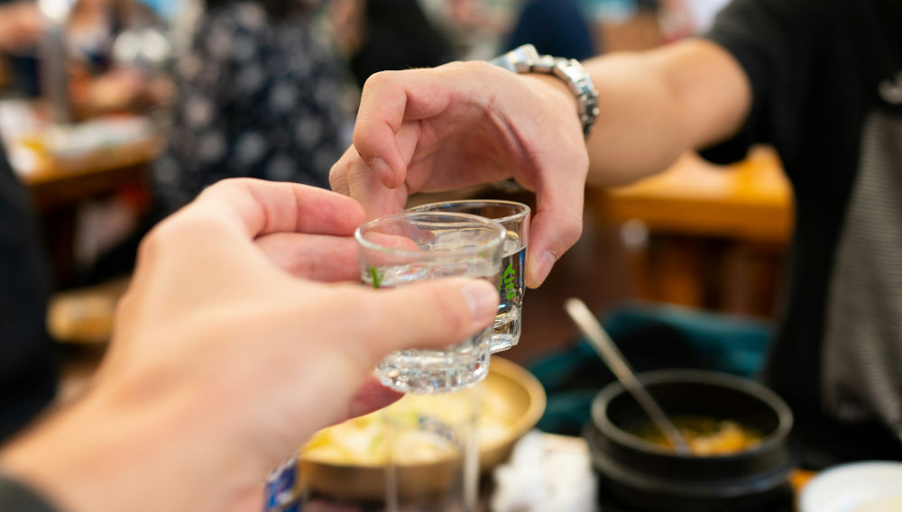 People toasting each other with shot glasses (Photo: The Creativv on Unsplash)