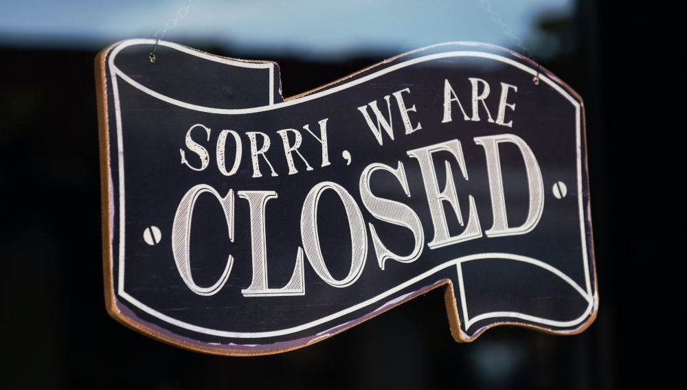 Black and white “Sorry, we are closed” sign in window (Photo by Tim Mossholder on Unsplash)