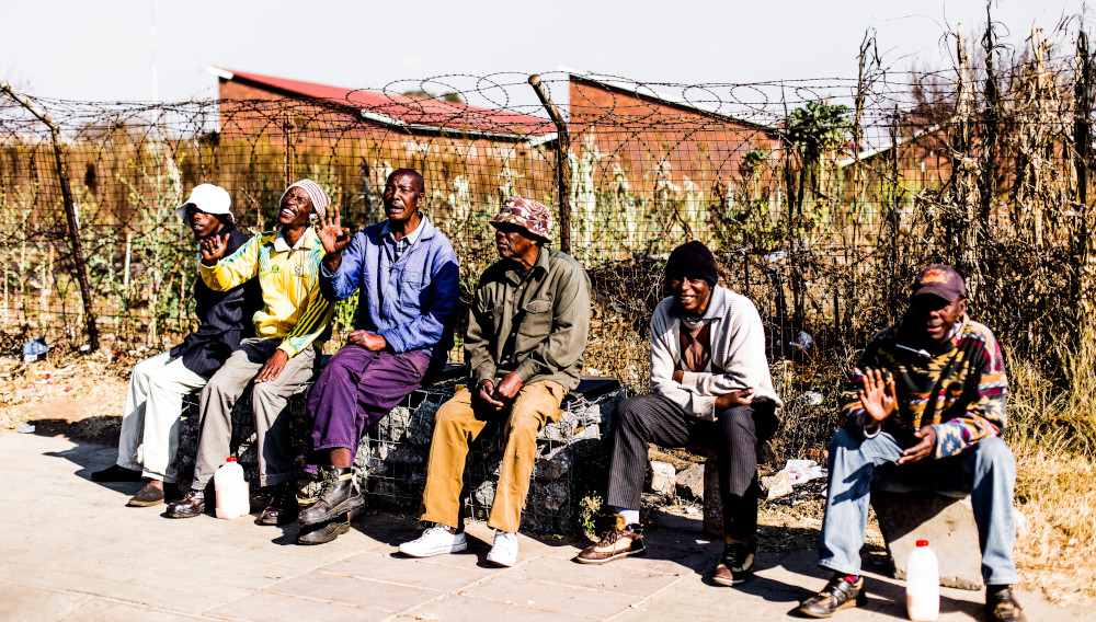 A group of man sitting together in Soweto, South Africa (Photo: Marco St, Unsplash)