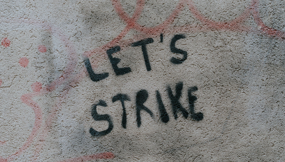 the word strike written on a wall (photo: Claudio Schwarz on Unsplash)