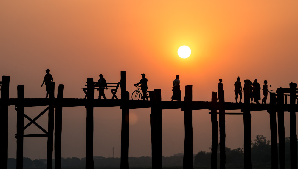 people on a bridge, sunset in the background (Photo: Ban Yido, Unsplash)