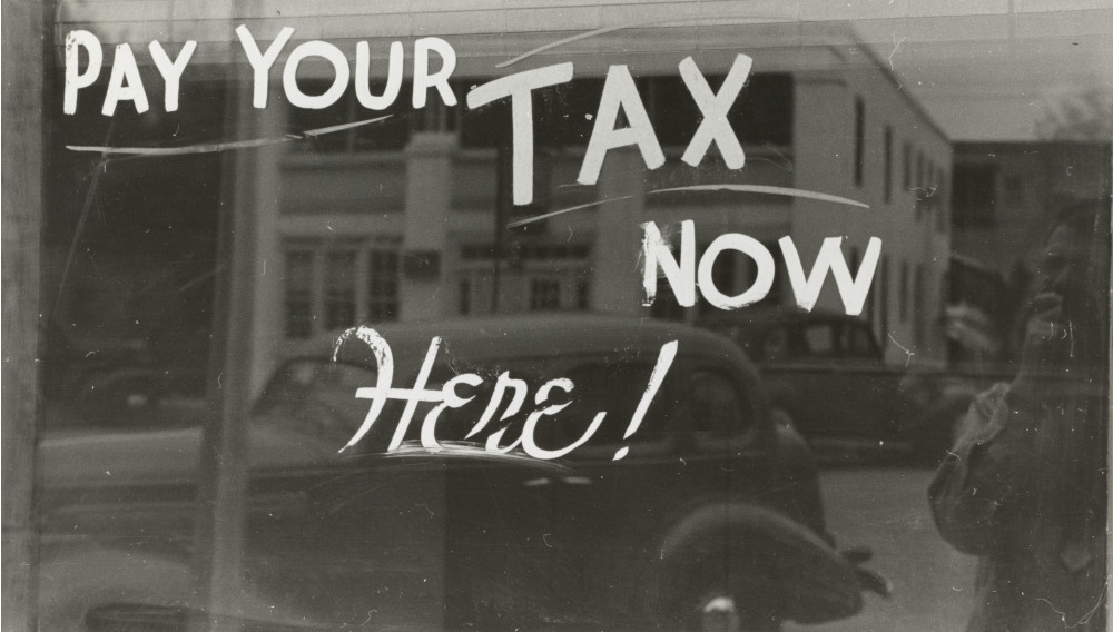„Pay your Tax now here” written on a wall (Photo: the-new-york-public-library on Unsplash)