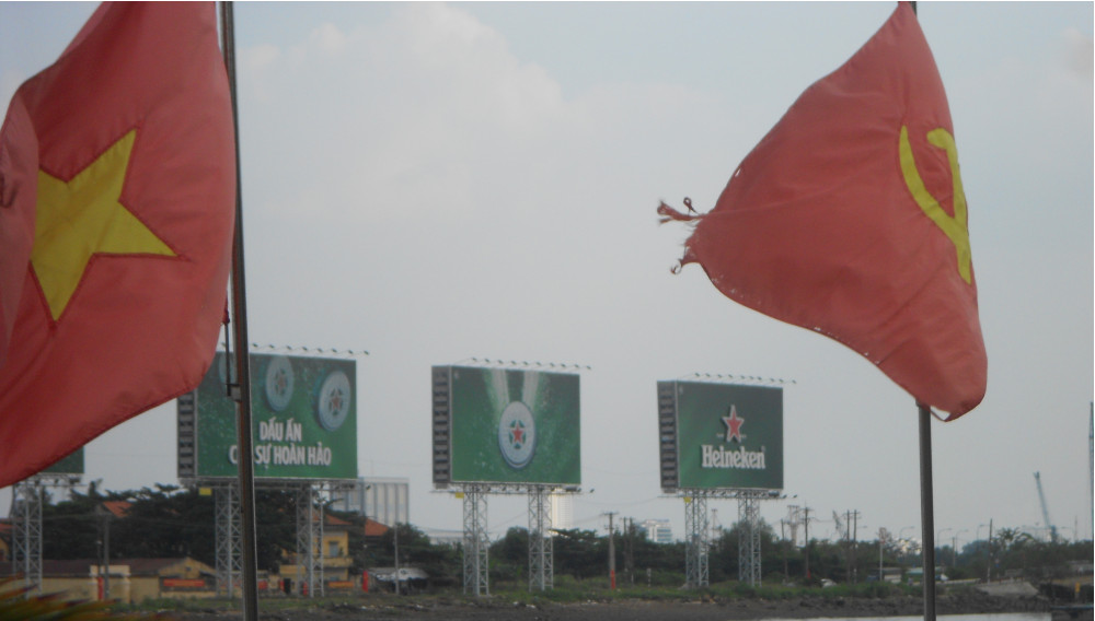 Vietnamese flags in front of billboards with beer advertisement (Photo: E. Hebeker)