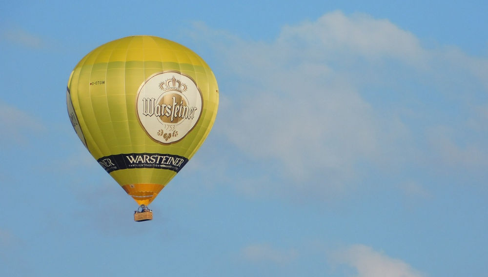 Advertising balloon sporting a Warteiner logo against a blue sky (Photo: Angelika Graczyk on Pixabay)