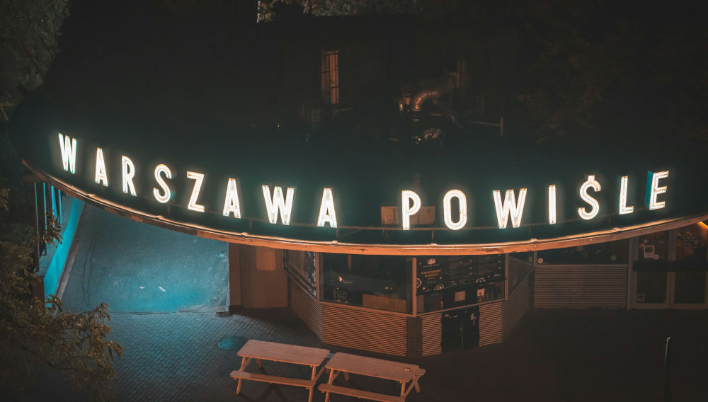 Neon sign saying Warszawa Powisle (Photo: John Nzoka on Unsplash)