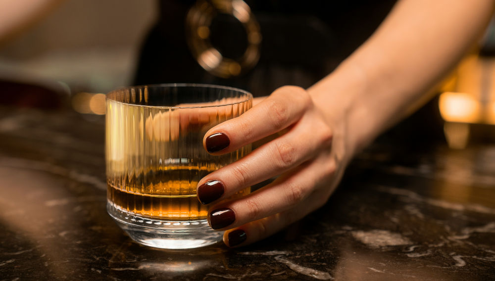 Hand holding a whisky glass (Photo: OurWhisky Foundation on Unsplash)