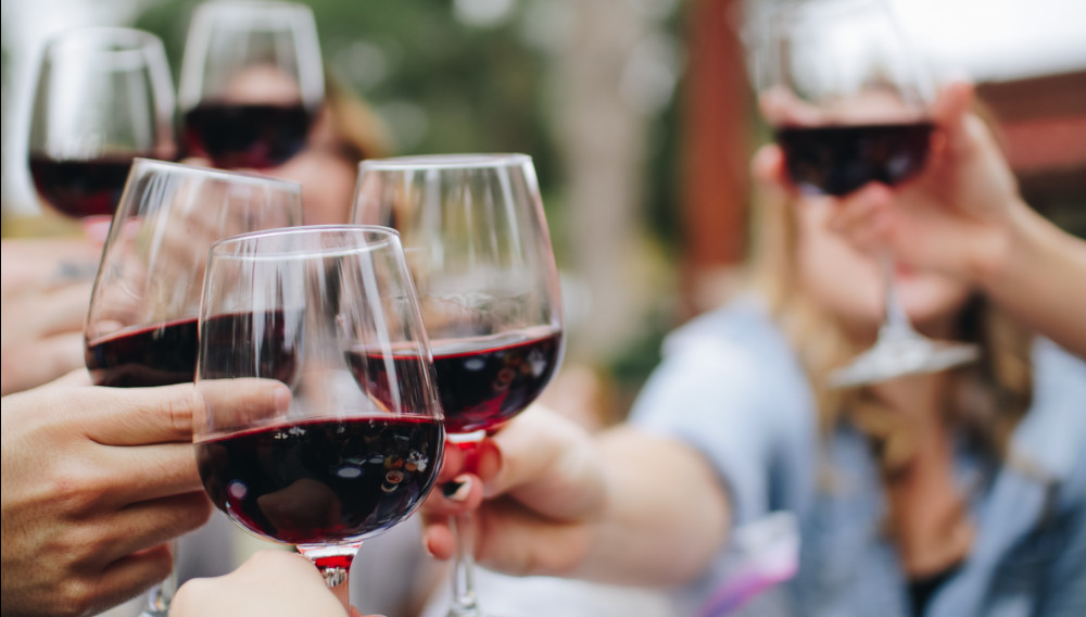People toasting with red wine (Photo: Kelsey Knight on Unsplash)