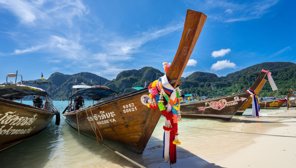 Wooden boats on a beach, Thailand (Photo by Frankie Spontelli on Unsplash)