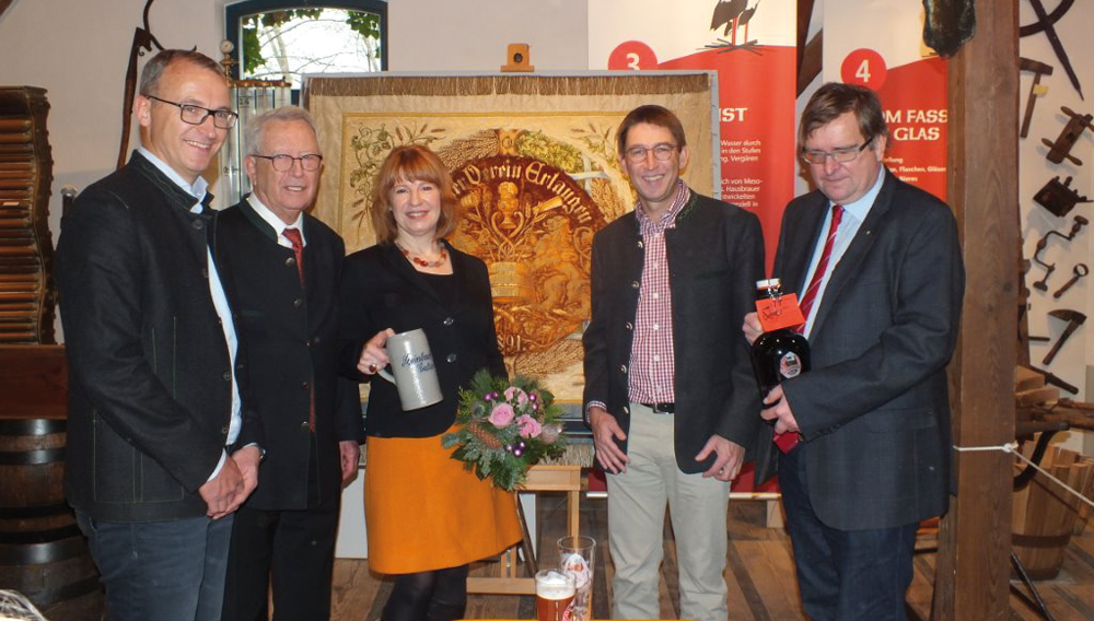 Christoph Gewalt, Dieter Gewalt, Brigitte Korn, Leiterin Stadtmuseum Erlangen, Jörg Gewalt und Dr. Andreas Jakob (v.li.) vor der Fahne des Brauer-Vereins Erlangen aus dem Jahre 1891