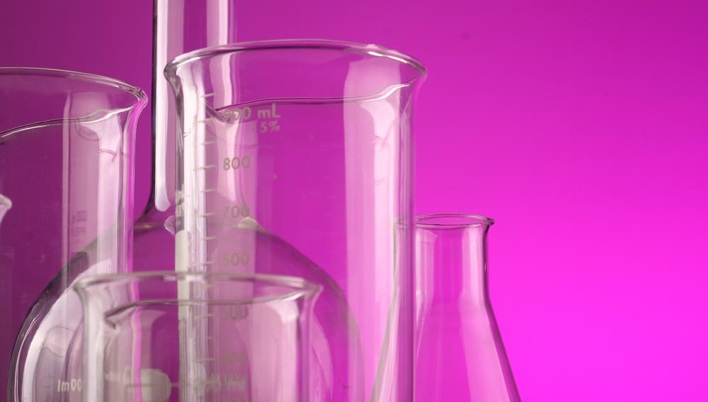 Laborglas-Behälter vor violettem Hintergrund