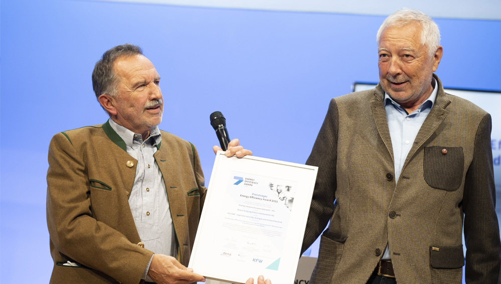 Hans-Jürgen Iwan und Dr. Georg Schuh präsentieren die Urkunde des Energy Efficiency Award 2021 in der Kategorie „Think Big! Komplexe Energiewendeprojekte“