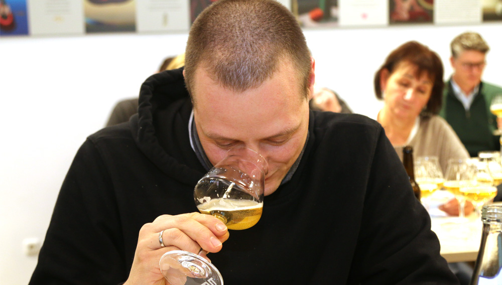 Mann riecht an einem Glas mit Bier
