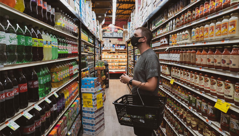 Mann steht vor einem Getränkeregal im Supermarkt (Foto: Atorns auf unplashed)