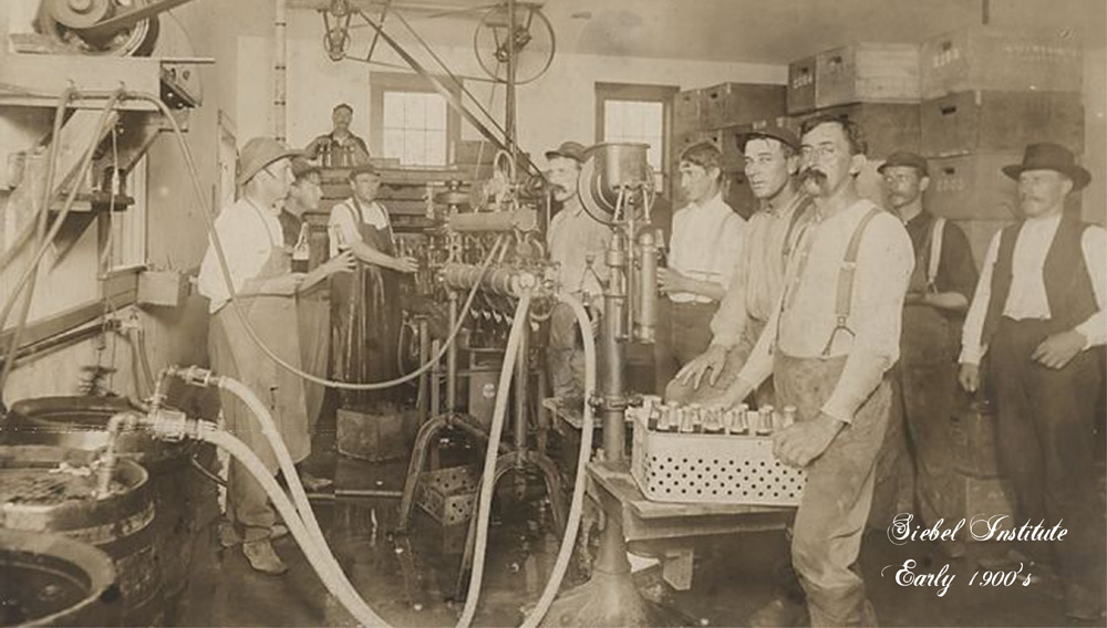 Schwarz-Weiß-Foto von mehreren Personen bei der Arbeit an Brauereimaschinen bei Siebel um 1900 (Foto: The Siebel Institute)