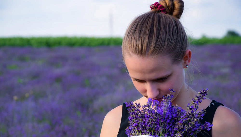 Frau riecht an Lavendelblüten (Foto: Richárd Ecsedi auf Unsplash)