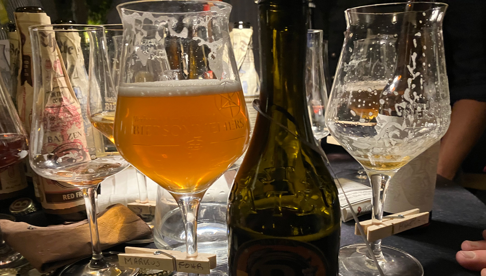 Biergläser und Flasche auf dunklem Tisch